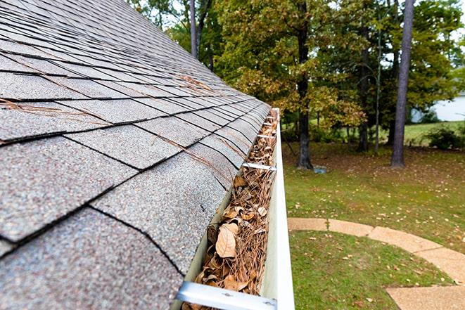 leaves and debris clogging a residential gutter